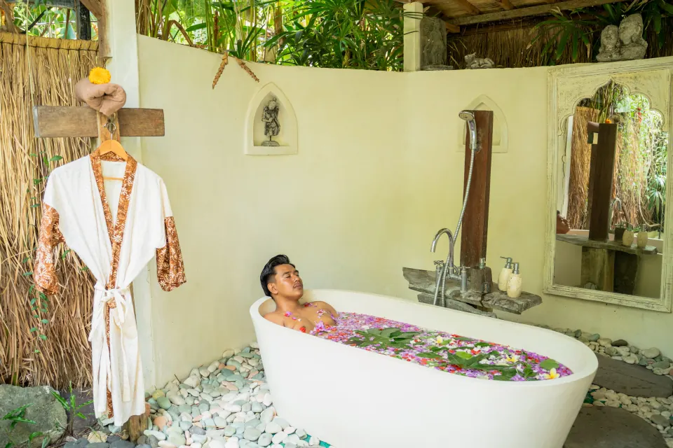A guest relaxing in a flower bath in the spa bathing room